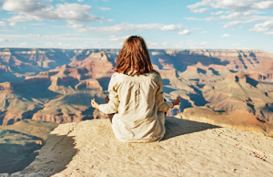 Picture of a young woman meditating outside.