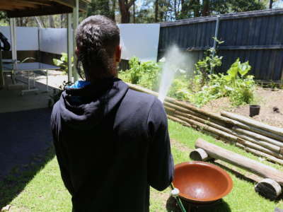 A resident waters some of the plants at the Coffs Harbour residential centre's veggie patch.